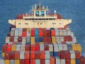 Les conteneurs sont empilés sur le pont d'un cargo alors qu'il est en cours dans le port de New York.