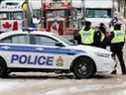 La police patrouille une barricade tandis que des véhicules bloquent les rues du centre-ville alors que les camionneurs et les partisans continuent de protester contre les mandats de vaccination contre la maladie à coronavirus (COVID-19) à Ottawa, Ontario, Canada, le 3 février 2022. 