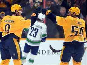 L'ailier gauche des Nashville Predators Filip Forsberg (9) célèbre avec le défenseur Roman Josi (59) après un but lors de la deuxième période contre les Canucks de Vancouver au Bridgestone Arena.