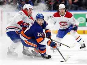 Mathew Barzal (13) des Islanders de New York contrôle la rondelle contre Rem Pitlick (32) et Alexander Romanov (27) des Canadiens lors de la première période à l'UBS Arena le dimanche 20 février 2022, à Elmont, NY