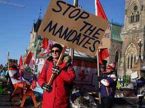 Des camionneurs et leurs partisans bloquent les rues lors d'une manifestation contre le mandat du vaccin près des édifices du Parlement le 15 février 2022 à Ottawa, Ontario, Canada.