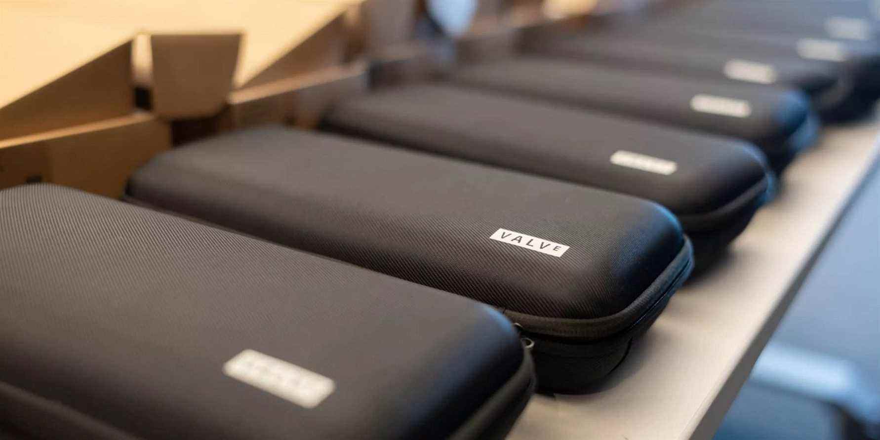 A row of Steam Deck devices inside carry cases.