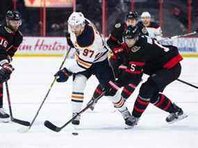 L'huileur d'Edmonton Connor McDavid et le sénateur d'Ottawa Nick Holden se battent pour la rondelle lors de leur match au Centre Canadian Tire d'Ottawa hier soir.  Getty Images