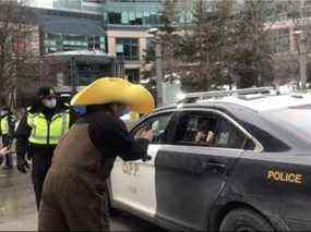 À 13 h jeudi à l'extérieur du World Exchange Plaza au centre-ville d'Ottawa, un homme a tourné une vidéo semblant montrer un agent de la Police provinciale de l'Ontario permettant à des personnes à l'arrière d'une voiture de patrouille marquée de prendre des photos.