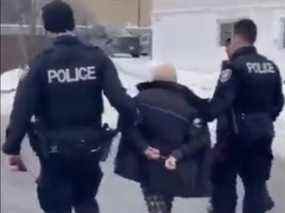 Une capture d'écran d'une vidéo d'un Gerry Charlebois menotté avec des agents de la police d'Ottawa le lundi 7 février 2022.