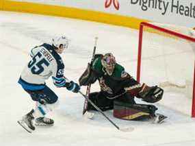 Le but des Coyotes de l'Arizona, Scott Wedgewood (31 ans), fait l'arrêt de pénalité contre le centre des Jets de Winnipeg Mark Scheifele (55 ans) au cours de la troisième période au Gila River Arena de Glendale, en Arizona, le 27 février 2022.