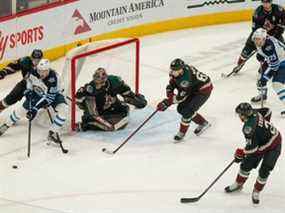 L'ailier gauche des Jets de Winnipeg Pierre-Luc Dubios (81) travaille la rondelle près du but contre les Coyotes de l'Arizona lors de la deuxième période au Gila River Arena de Glendale, en Arizona, le 27 février 2022.