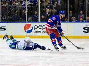 L'ailier gauche des Rangers de New York Chris Kreider (20) tire tandis que le défenseur des Canucks de Vancouver Luke Schenn (2) plonge pour interrompre le jeu au cours de la deuxième période au Madison Square Garden.  Le gardien de chèvre des Canucks Thatcher Demko (pas sur la photo) a effectué l'arrêt.