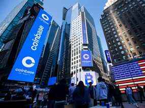 Les moniteurs affichent la signalisation Coinbase lors de l'introduction en bourse de la société au Nasdaq MarketSite à New York, aux États-Unis