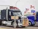 Des manifestants anti-mandat se rassemblent alors qu'un convoi de camions bloque l'autoroute au passage frontalier américain à Coutts, en Alberta, le lundi 31 janvier 2022.