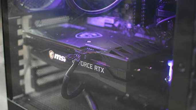 LE MSI GeForce RTX 3060 Gaming X Trio derrière le panneau de verre d'un boîtier PC.