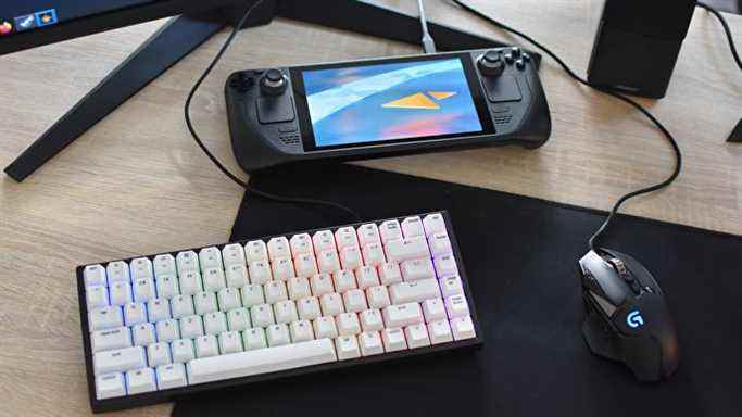 Le Steam Deck à côté d'une souris et d'un clavier de jeu, qui lui sont connectés via un hub USB-C.