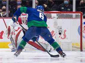 Le gardien des Canadiens de Montréal Sam Montembeault, de dos, arrête Brock Boeser des Canucks de Vancouver lors de la deuxième période d'un match de hockey de la LNH à Vancouver, le mercredi 9 mars 2022.