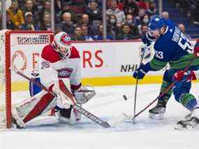 Le gardien des Canadiens de Montréal Sam Montembeault (35 ans) fait un arrêt sur l'attaquant des Canucks de Vancouver Bo Horvat (53 ans) en première période au Rogers Arena.