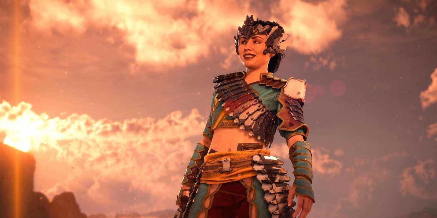 talanah dans son métal, son armure de plumes et sa coiffe souriante dos à un ciel bleu avec le soleil se couchant sur la gauche