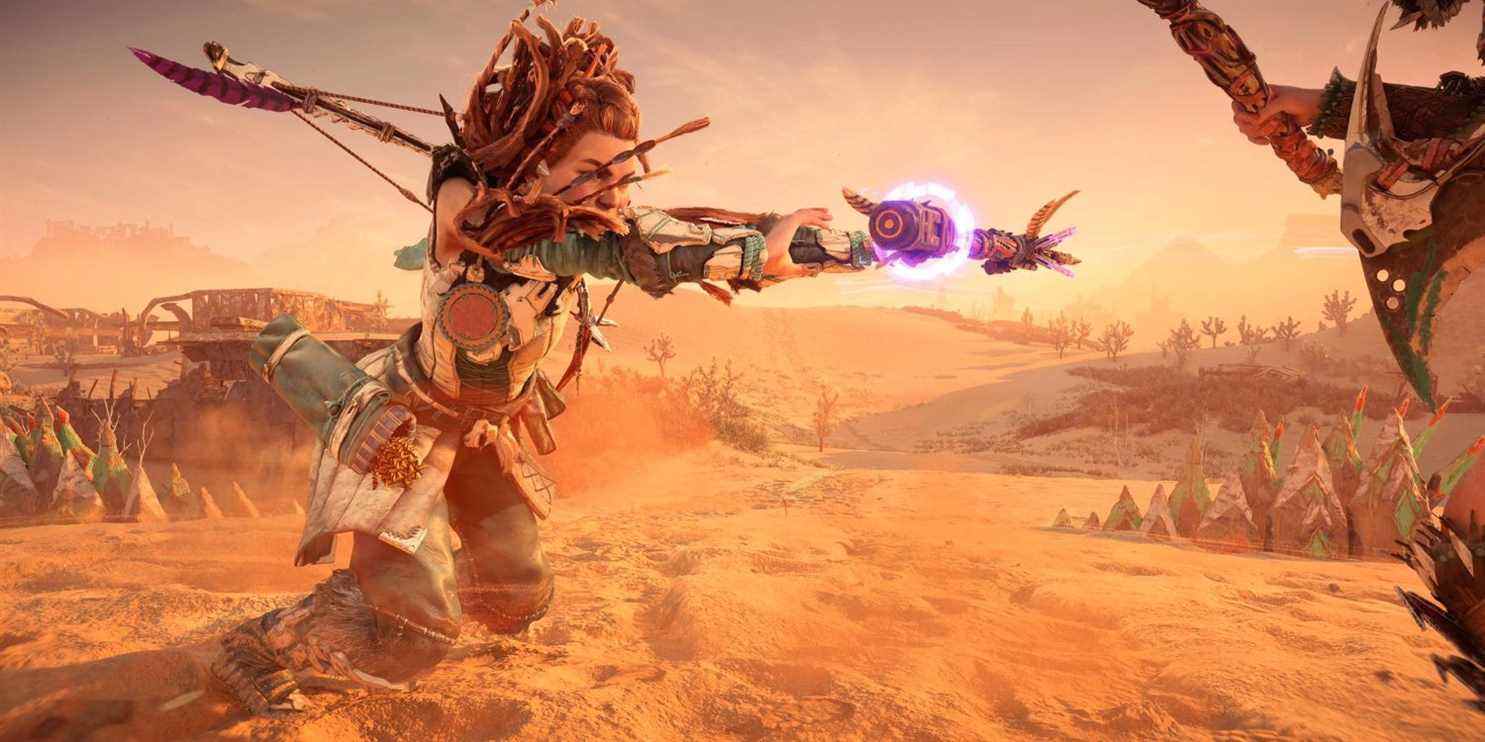 aloy debout dans un désert balançant sa lance avec une lueur violette dessus 