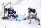 Le gardien de but des Maple Leafs Petr Mrazek effectue un arrêt alors que le défenseur des Leafs Justin Holl couvre Dylan Cozens des Sabres de Buffalo lors de la première période de la Classique Héritage au Tim Hortons Field à Hamilton le dimanche 13 mars 2022. 