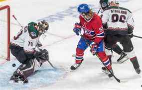 L'ailier gauche des Canadiens de Montréal Michael Pezzetta (55) regarde la rondelle derrière le gardien de but des Coyotes de l'Arizona Karel Vejmelka (70) lors de la première période d'action de la LNH au Centre Bell de Montréal le mardi 15 mars 2022.