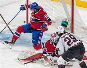 La rondelle navigue devant le gardien de but des Canadiens de Montréal Sam Montembeault (35) et le centre des Canadiens de Montréal Mike Hoffman (68) sur un tir du centre des Coyotes de l'Arizona Barrett Hayton (29) lors de la première période d'action de la LNH au Centre Bell de Montréal le mardi 15 mars. 2022.