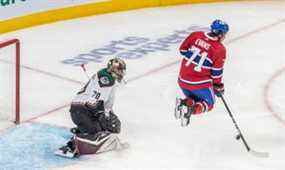 Le centre des Canadiens de Montréal Jake Evans (71) bondit devant le gardien de but des Coyotes de l'Arizona Karel Vejmelka (70) pour éviter un tir du point lors de la 3e période d'action de la LNH au Centre Bell de Montréal le mardi 15 mars 2022.