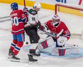 Une rondelle navigue à travers le pli du gardien de but des Canadiens de Montréal Cayden Primeau (30) avec son coéquipier le défenseur Chris Wideman (20) et l'ailier droit des Coyotes de l'Arizona Christian Fischer (36) à la porte lors de la 3e période de l'action de la LNH au Centre Bell de Montréal mardi, 15 mars 2022.