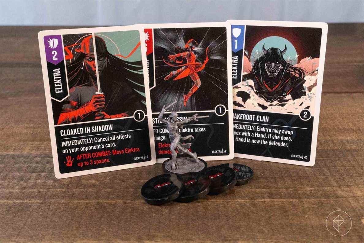 Une figurine Elektra avec trois cartes associées du deck du personnage.