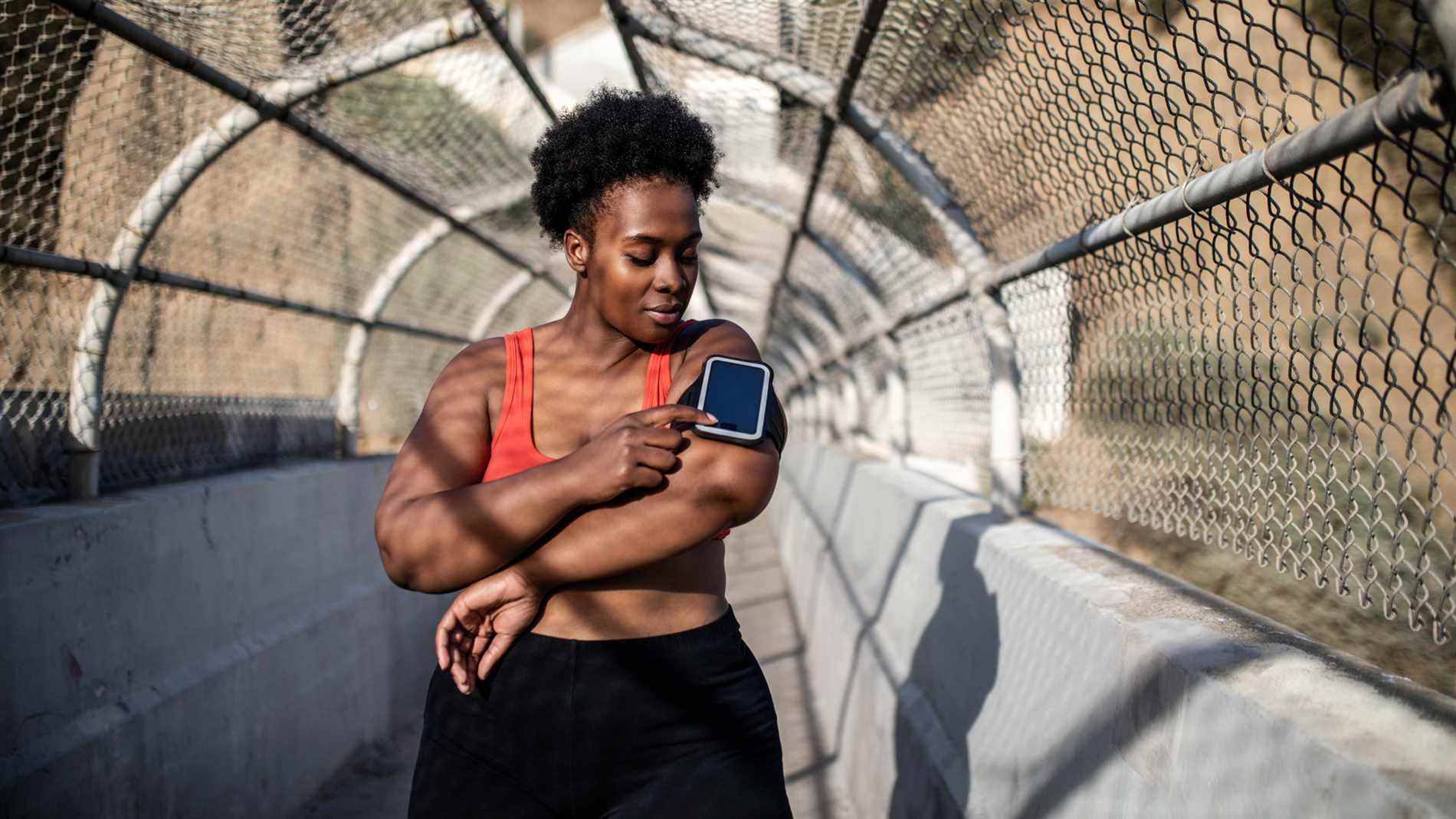 Image d'une femme vérifiant le tracker fitnss pendant la course