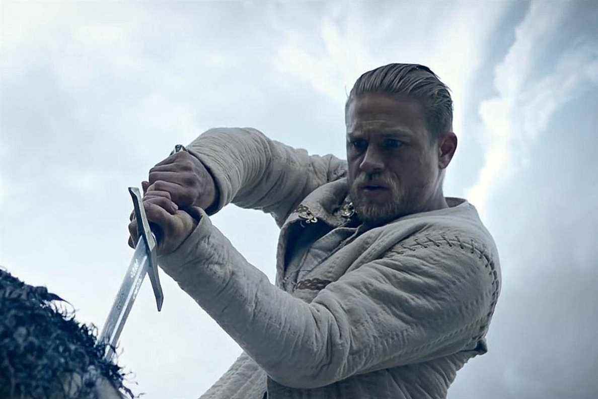 Charlie Hunnam dans le rôle d'Arthur tirant Excalibur de la pierre dans King Arthur: Legend of the Sword.