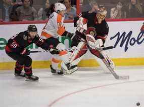 Le gardien des Sénateurs Anton Forsberg éloigne la rondelle de l'ailier droit des Flyers Travis Konecny ​​en troisième période.