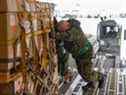 Des membres des Forces armées canadiennes chargent du matériel militaire à destination de l'Ukraine à bord d'un CC-177 Globemaster à la BFC Trenton.