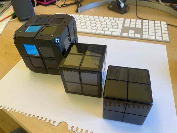 Trois prototypes Wowcube sont assis sur un bureau.