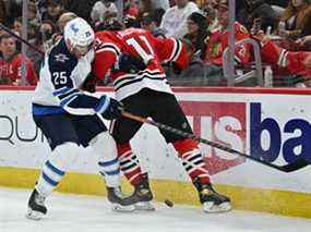 Paul Stastny (25 ans) des Jets de Winnipeg se bat avec Taylor Raddysh (11 ans) des Blackhawks de Chicago pour le contrôle de la rondelle en troisième période le 20 mars 2022 au United Center de Chicago.