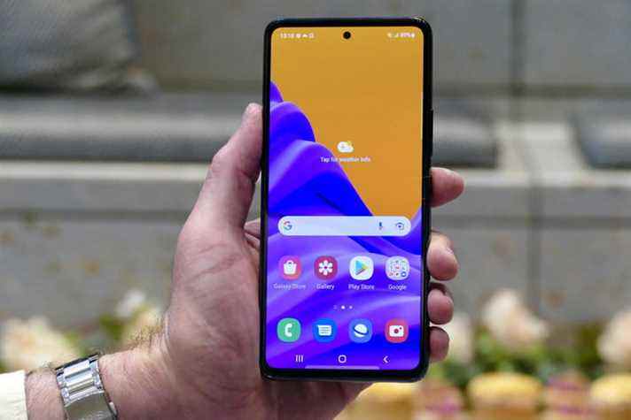 Une main tient le Samsung Galaxy A53 avec l'écran 5G affiché.