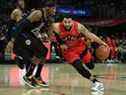 Le garde des Raptors Fred VanVleet (23 ans) se déplace vers le panier contre l'attaquant des Los Angeles Clippers Robert Covington (23 ans) mercredi.