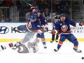 Casey Cizikas, numéro 53 des Islanders de New York, trébuche sur Mathieu Joseph, numéro 21 des Sénateurs d'Ottawa, lors de la première période à l'UBS Arena le 22 mars 2022 à Elmont, New York.