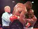 L'arbitre Lane Mills (L) intervient alors qu'Evander Holyfield (R) réagit après que Mike Tyson se soit mordu l'oreille au troisième tour de leur combat de championnat poids lourd WBA au MGM Grand Garden Arena de Las Vegas, NV le 28 juin.  Holyfield a gagné par disqualification après l'incident mordant.      