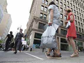 Une personne transporte un sac à provisions de La Maison Simons Inc. à Montréal.