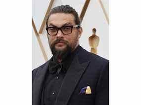 Jason Momoa porte un mouchoir aux couleurs du drapeau ukrainien en signe de solidarité avec l'Ukraine alors que l'invasion du pays par la Russie se poursuit alors qu'il pose sur le tapis rouge lors des arrivées des Oscars à la 94e cérémonie des Oscars à Hollywood, Los Angeles, Californie. , 27 mars 2022.