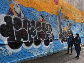 Les artistes Sean Cao et Katharine Yi devant leur peinture murale, qui a été vandalisée à Chinatown.