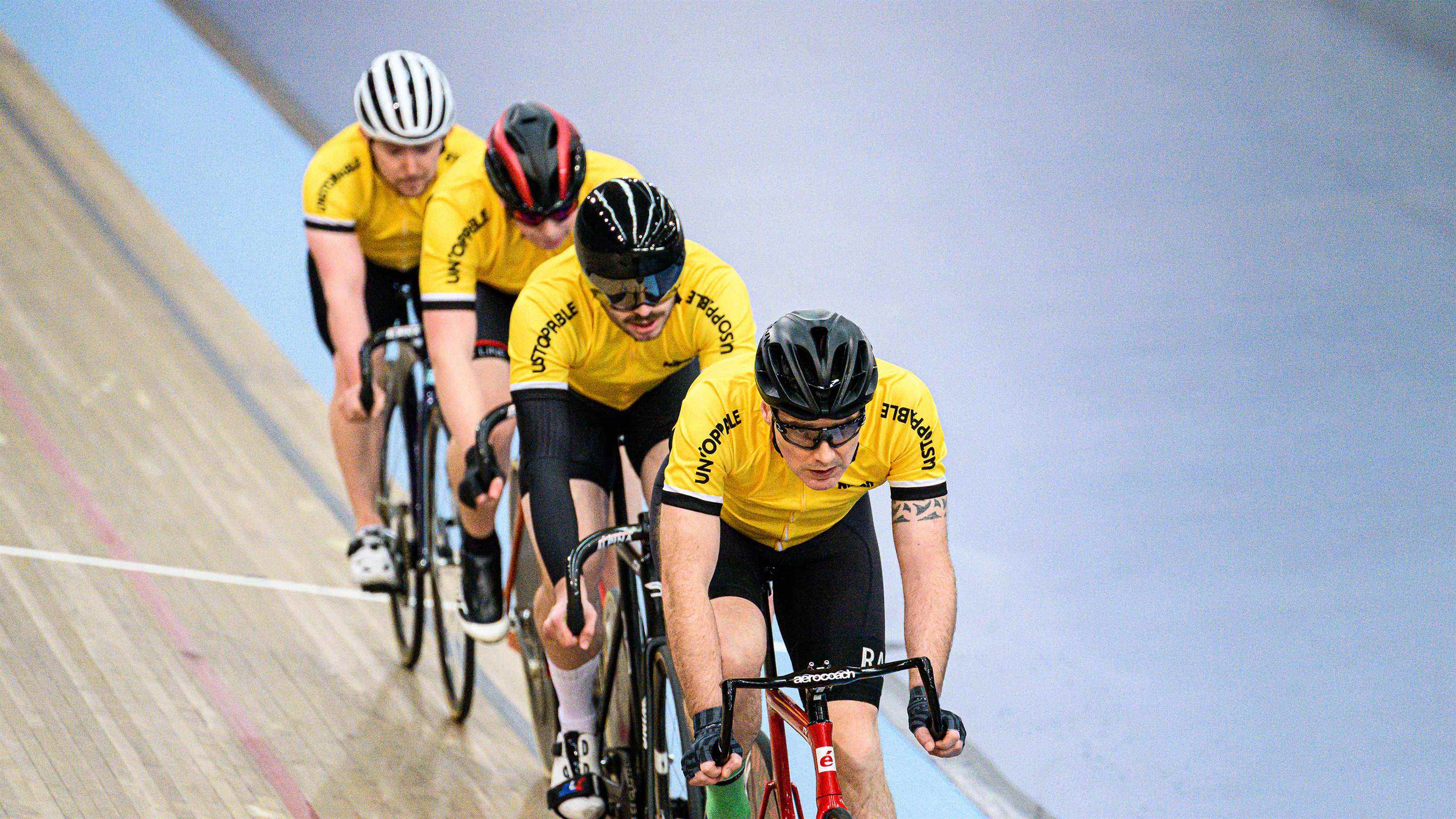 Quatre cyclistes roulant autour d'un vélodrome