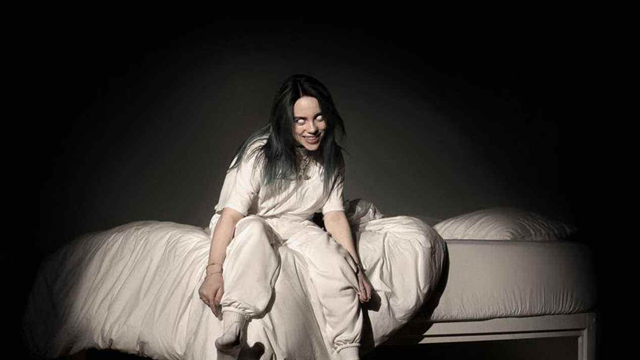 billie eilish assise sur un lit vêtue de blanc