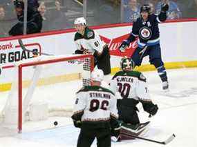 Mark Scheifele des Jets de Winnipeg marque devant Karel Vejmelka (70) des Coyotes de l'Arizona en première période lors d'un match le 27 mars 2022 au Canada Life Centre à Winnipeg.