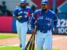 Teoscar Hernandez des Blue Jays, à droite, et Vladimir Guerrero Jr. courent jusqu'à la pirogue avant le début d'un match de baseball d'entraînement de printemps au TD Ballpark, à Dunedin, en Floride, le dimanche 27 mars 2022.