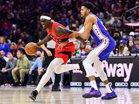 L'attaquant des Raptors de Toronto Pascal Siakam conduit avec le ballon contre l'attaquant des 76ers de Philadelphie Tobias Harris au premier quart au Wells Fargo Center de Philadelphie, Pennsylvanie, le 20 mars 2022.