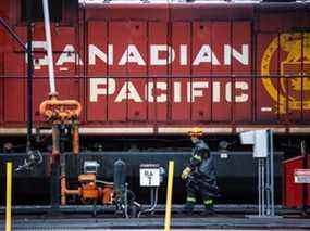 Un employé du CP Rail passe devant des locomotives dans les gares de triage d'Alyth à Calgary.