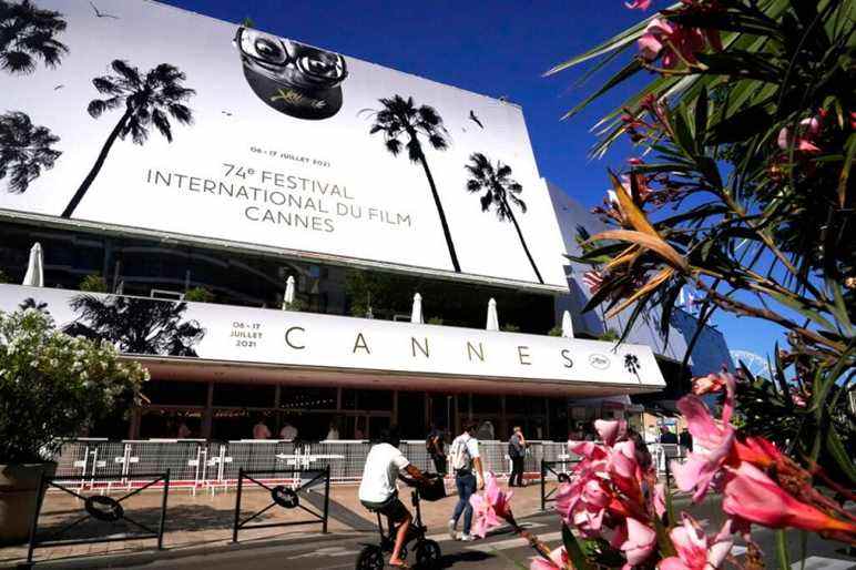 Members of the public walk in front of the Palais des Festival prior to the 74th international film festival, Cannes, southern France, July 5, 2021. The Cannes film festival runs from July 6 - July 17, 2021. (AP Photo/ Brynn Anderson)