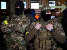 Deux combattants étrangers du Royaume-Uni posent pour une photo alors qu'ils se préparent à partir pour la ligne de front dans l'est de l'Ukraine, après l'invasion russe.  Ils sont photographiés à la gare principale de Lviv, en Ukraine, le 5 mars 2022.