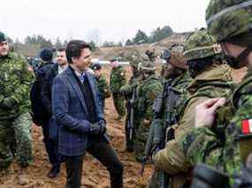 Le premier ministre du Canada, Justin Trudeau, s'entretient avec des soldats lors d'une visite de la base militaire d'Adazi, au nord-est de Riga, en Lettonie, le 8 mars 2022.