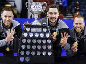 Le capitaine de l'équipe Wild Card One, Brad Gushue, à gauche, le deuxième Brett Gallant, au centre, et le premier Geoff Walker célèbrent leur victoire sur l'équipe de l'Alberta au Tim Hortons Brier à Lethbridge, en Alberta, le dimanche 13 mars 2022.