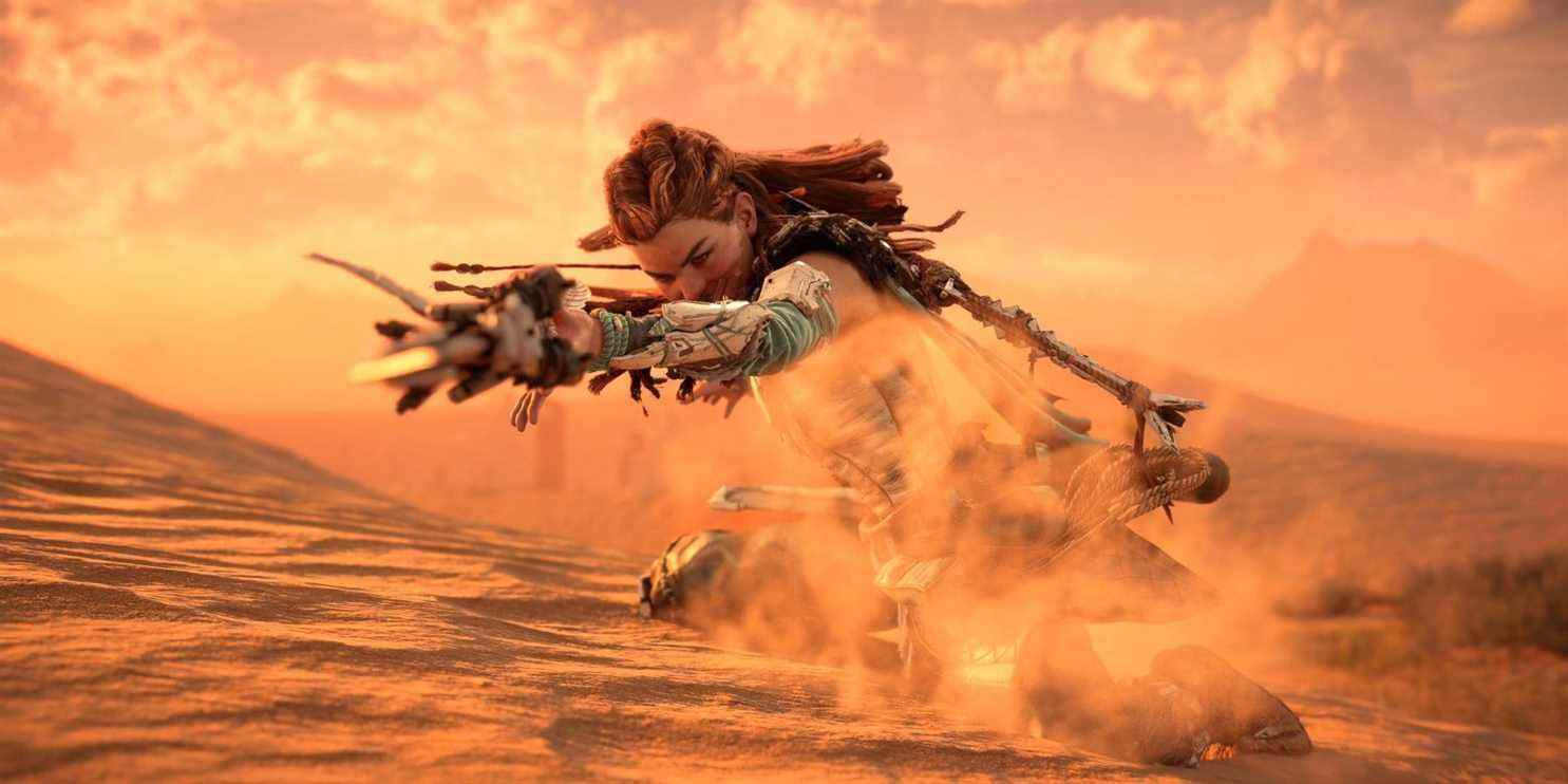 aloy balançant sa lance en position accroupie sur une dune de sable dans un désert